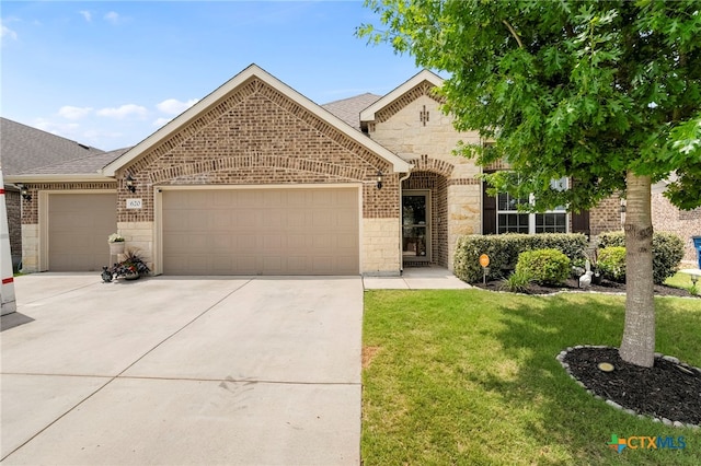 view of front of home with a front yard, concrete driveway, stone siding, and a garage