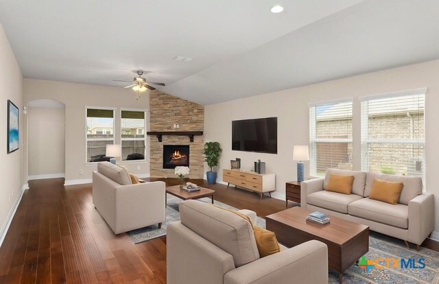 620 Ridgemeadow Dr, New Braunfels, TX 78130 - living room with ceiling fan, a fireplace, dark wood-style flooring, lofted ceiling, and arched walkways
