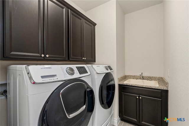 laundry room with a sink, cabinet space, and washer and clothes dryer