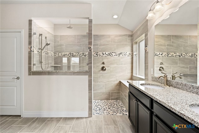 full bath featuring double vanity, walk in shower, recessed lighting, and a sink