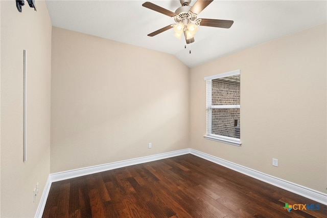 spare room with baseboards, ceiling fan, dark wood-style flooring, and vaulted ceiling