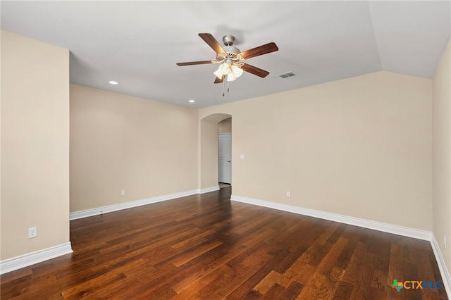 empty room with arched walkways, visible vents, ceiling fan, and wood finished floors