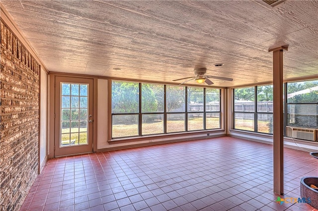 unfurnished sunroom featuring ceiling fan, cooling unit, wooden ceiling, and a wealth of natural light