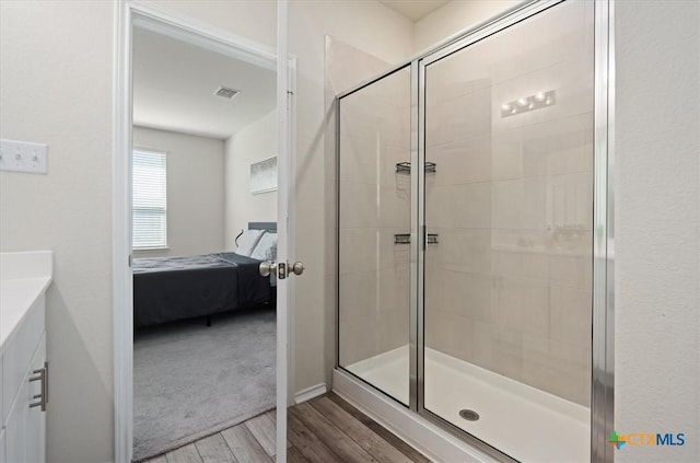 212 Gunther Way, Taylor, TX 76574 - ensuite bathroom with wood finished floors, a stall shower, and vanity