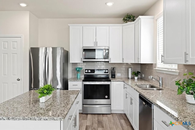 212 Gunther Way, Taylor, TX 76574 - kitchen with stainless steel appliances, a sink, plenty of natural light, white cabinets, and recessed lighting
