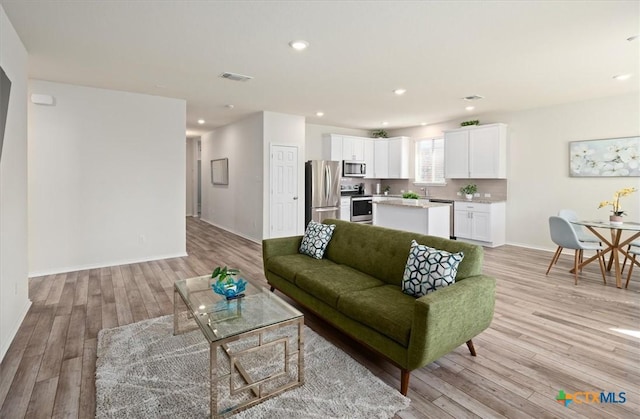 212 Gunther Way, Taylor, TX 76574 - living room featuring light wood-style flooring, baseboards, and recessed lighting