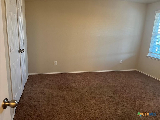 unfurnished room with dark carpet