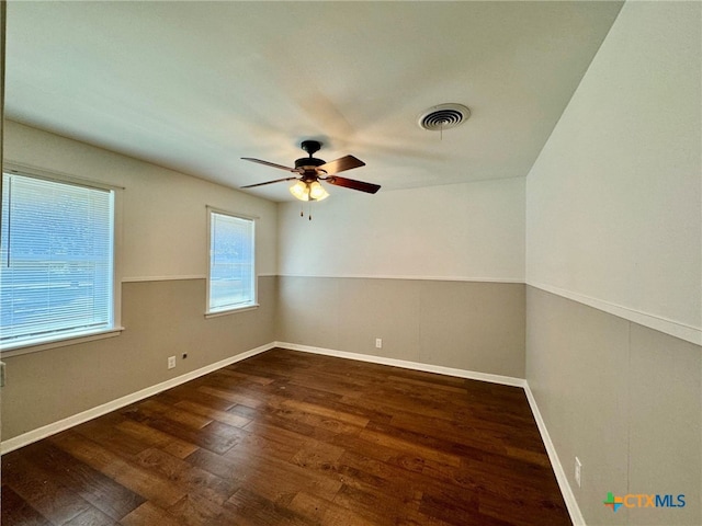 empty room with ceiling fan and dark hardwood / wood-style floors