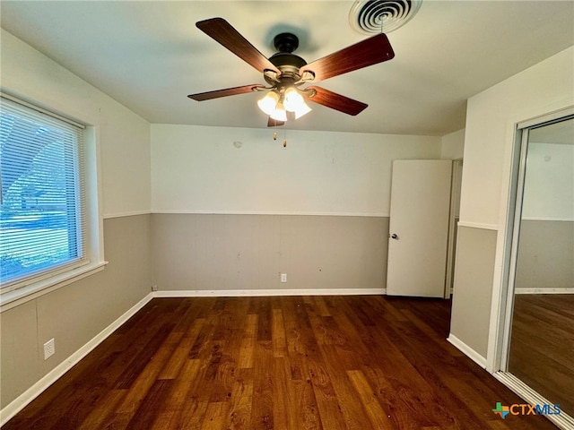 spare room featuring dark hardwood / wood-style flooring and ceiling fan