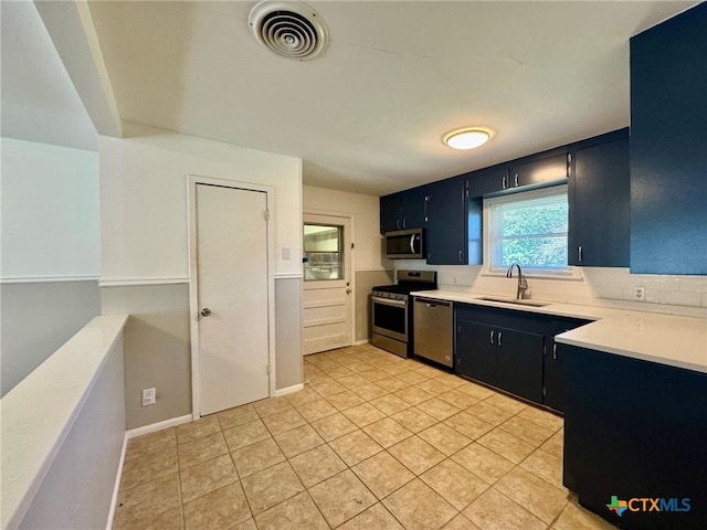 kitchen with stainless steel appliances, sink, backsplash, and light tile patterned floors