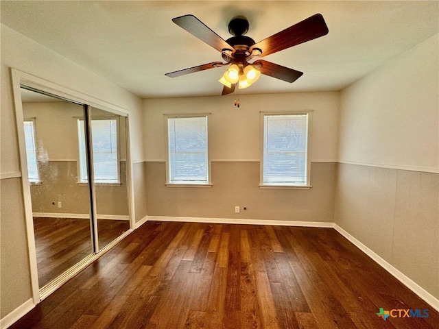 unfurnished bedroom with ceiling fan, dark hardwood / wood-style floors, and a closet