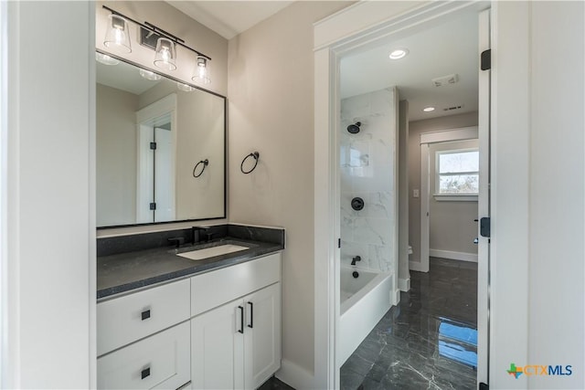 bathroom featuring tiled shower / bath and vanity