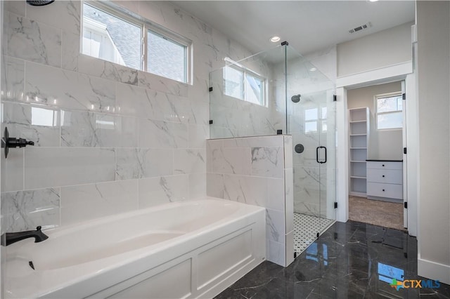 bathroom featuring a wealth of natural light and independent shower and bath