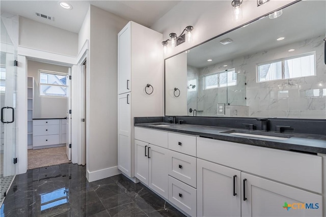 bathroom featuring an enclosed shower, vanity, and plenty of natural light