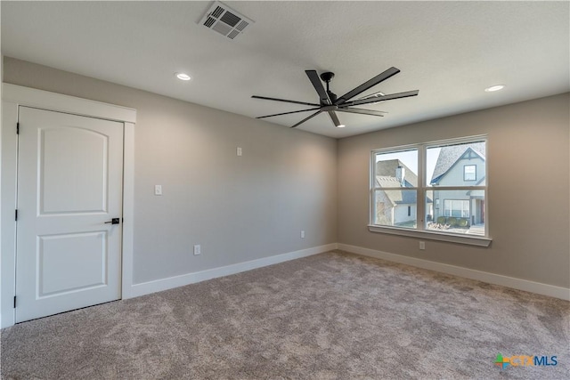 spare room featuring ceiling fan and light colored carpet