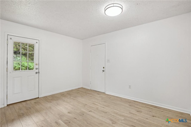 712 N 19th St, Copperas Cove, TX 76522 - foyer entrance featuring a textured ceiling, light wood finished floors, and baseboards