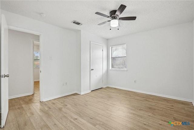 712 N 19th St, Copperas Cove, TX 76522 - unfurnished bedroom featuring light wood-type flooring, baseboards, a textured ceiling, and a ceiling fan