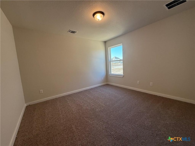 carpeted spare room with a textured ceiling