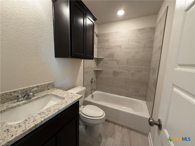 full bathroom with tiled shower / bath, vanity, and toilet