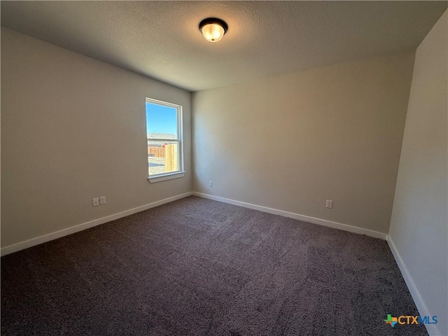 carpeted empty room with a textured ceiling