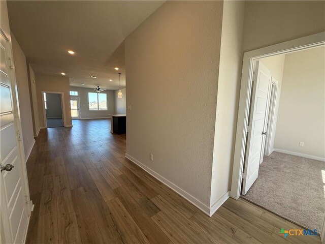 kitchen with kitchen peninsula, stainless steel appliances, wood-type flooring, and ceiling fan