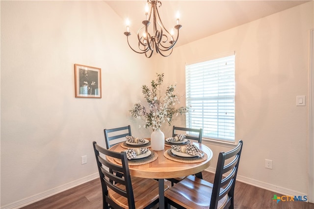 dining area with dark hardwood / wood-style floors and a chandelier