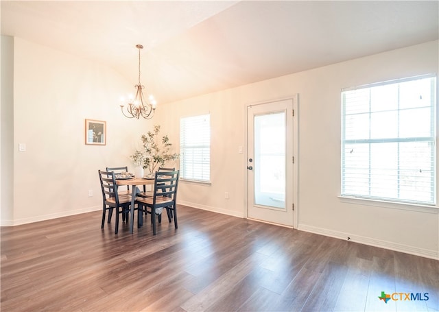 dining room with lofted ceiling, dark wood-type flooring, and a notable chandelier