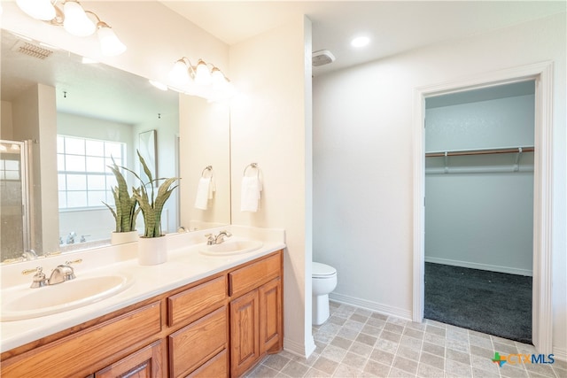 bathroom with toilet, a shower, and vanity