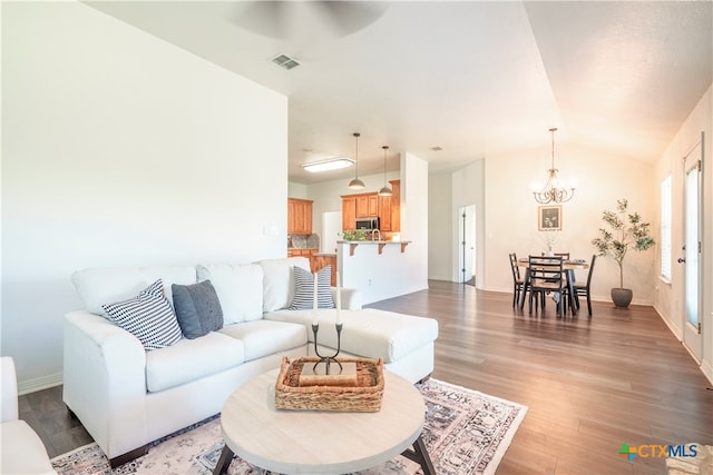 living room featuring lofted ceiling, hardwood / wood-style flooring, and ceiling fan