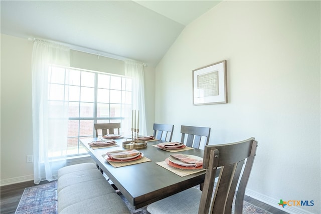 dining area featuring dark wood-type flooring, lofted ceiling, and a healthy amount of sunlight