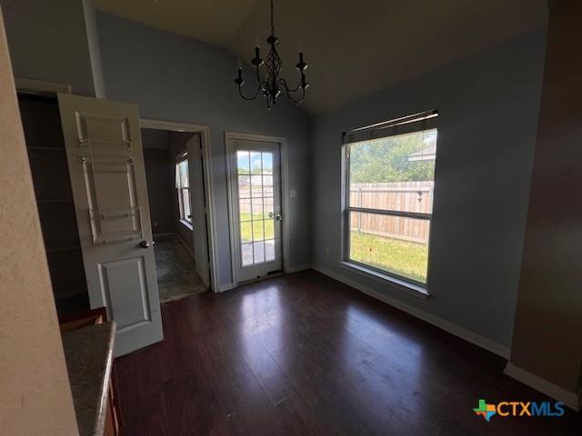 10234 Condor Loop, Waco, TX 76708 - unfurnished dining area featuring lofted ceiling, dark wood-style flooring, and a chandelier