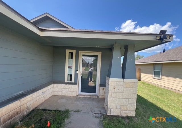 10234 Condor Loop, Waco, TX 76708 - entrance to property with covered porch, a lawn, and stone siding