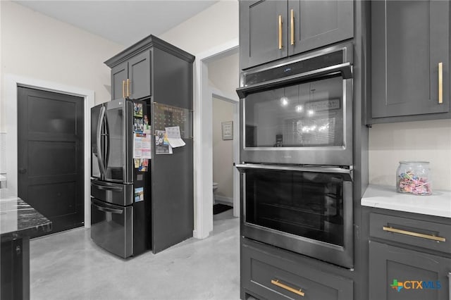 kitchen with appliances with stainless steel finishes, gray cabinets, and finished concrete flooring