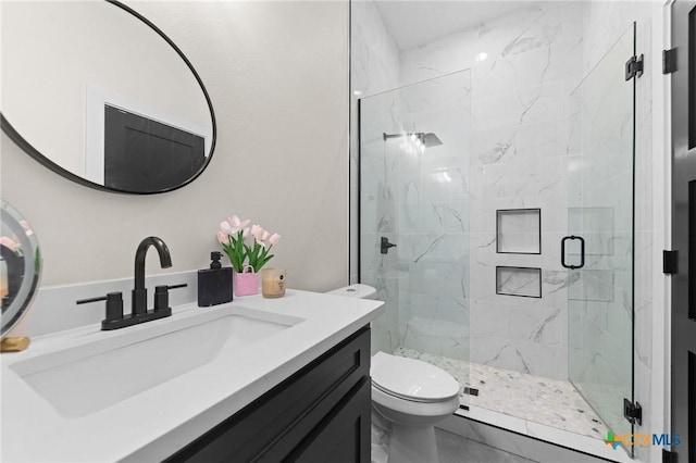 full bathroom with vanity, a marble finish shower, and toilet