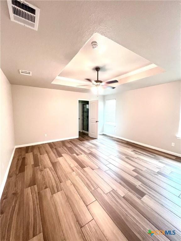 8302 Ridge Crest Dr, Killeen, TX 76542 - empty room with a tray ceiling, baseboards, a ceiling fan, and wood finished floors