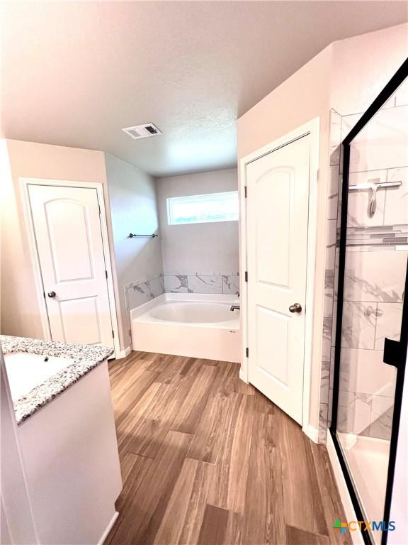 8302 Ridge Crest Dr, Killeen, TX 76542 - full bath featuring a garden tub, a stall shower, wood finished floors, and vanity