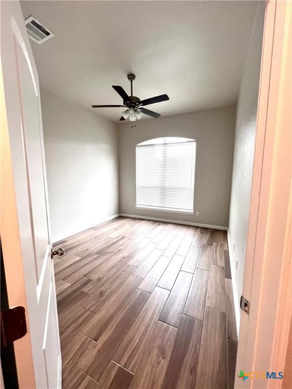8302 Ridge Crest Dr, Killeen, TX 76542 - unfurnished room featuring wood finished floors, ceiling fan, and baseboards