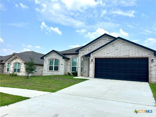 8302 Ridge Crest Dr, Killeen, TX 76542 - french country style house featuring a garage, a front lawn, concrete driveway, brick siding, and roof with shingles