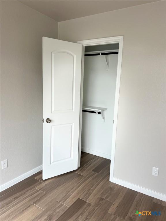 8302 Ridge Crest Dr, Killeen, TX 76542 - unfurnished bedroom featuring a closet, wood finished floors, and baseboards