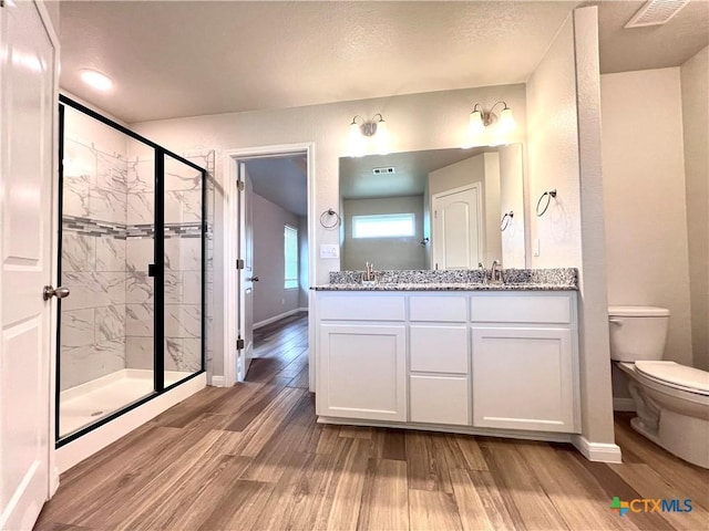 8302 Ridge Crest Dr, Killeen, TX 76542 - bathroom with toilet, wood finished floors, a shower stall, double vanity, and baseboards