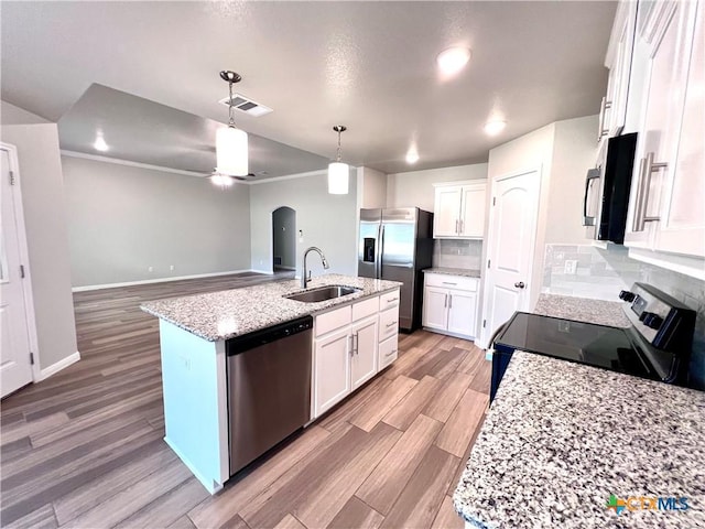 8302 Ridge Crest Dr, Killeen, TX 76542 - kitchen featuring appliances with stainless steel finishes, a sink, arched walkways, light wood-style flooring, and decorative light fixtures