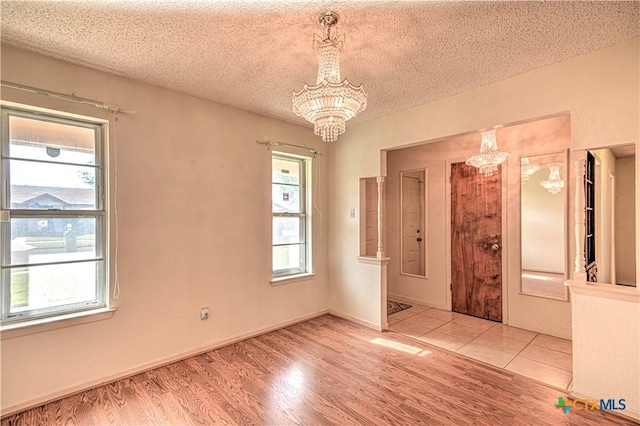 interior space featuring wood finished floors, a textured ceiling, and an inviting chandelier
