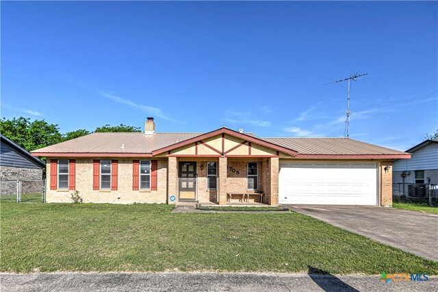 ranch-style home featuring a front lawn, driveway, an attached garage, fence, and brick siding