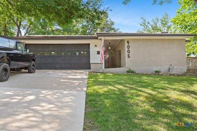 4005 Trailwood Dr, Temple, TX 76502 - view of front of house with an attached garage, a front lawn, brick siding, and concrete driveway