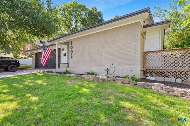 4005 Trailwood Dr, Temple, TX 76502 - view of front of house featuring brick siding, an attached garage, a front lawn, and driveway