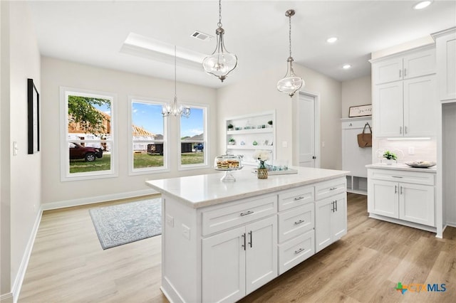 kitchen with light wood-style flooring, recessed lighting, decorative light fixtures, visible vents, and light countertops