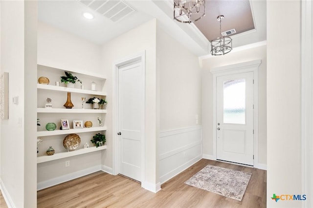 entrance foyer featuring a chandelier, visible vents, and wood finished floors