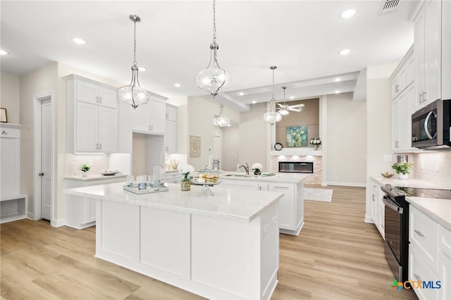 kitchen with recessed lighting, black range with electric stovetop, stainless steel microwave, and backsplash