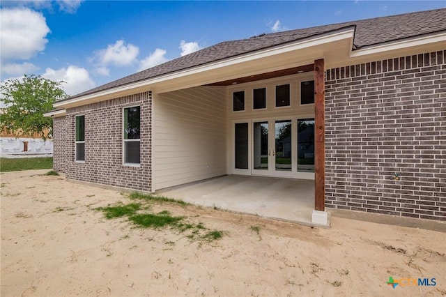 rear view of house featuring a patio and brick siding