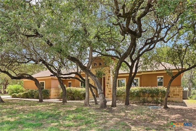 view of front of home featuring stucco siding and stone siding